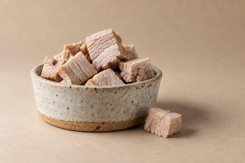 Can Dogs Eat Pork? Plain Cooked Lean Pork Yes, Bacon, Fat And Cured Pork No 1 A small ceramic dish holds diced plain cooked lean pork with the fat trimmed off.